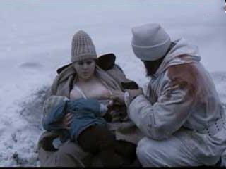 Hungry soldier drinks milk from the breast of a fat woman